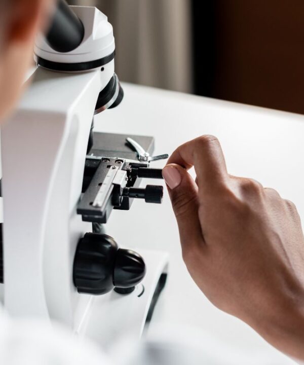 Scientist working with a microscope, highlighting advanced downstream processing techniques for high-quality bacteriophage production at Qeen Biotechnologies.