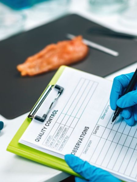 Scientist's hand performing quality control on chicken meat, ensuring food safety and detecting contaminants.