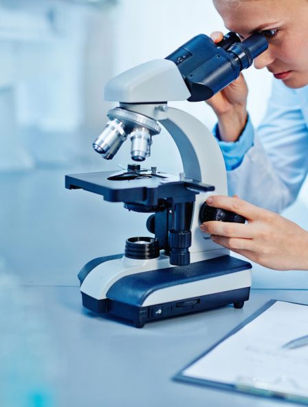 Scientist analyzing bacteria in a lab using a microscope, highlighting advanced research in microbiome science.